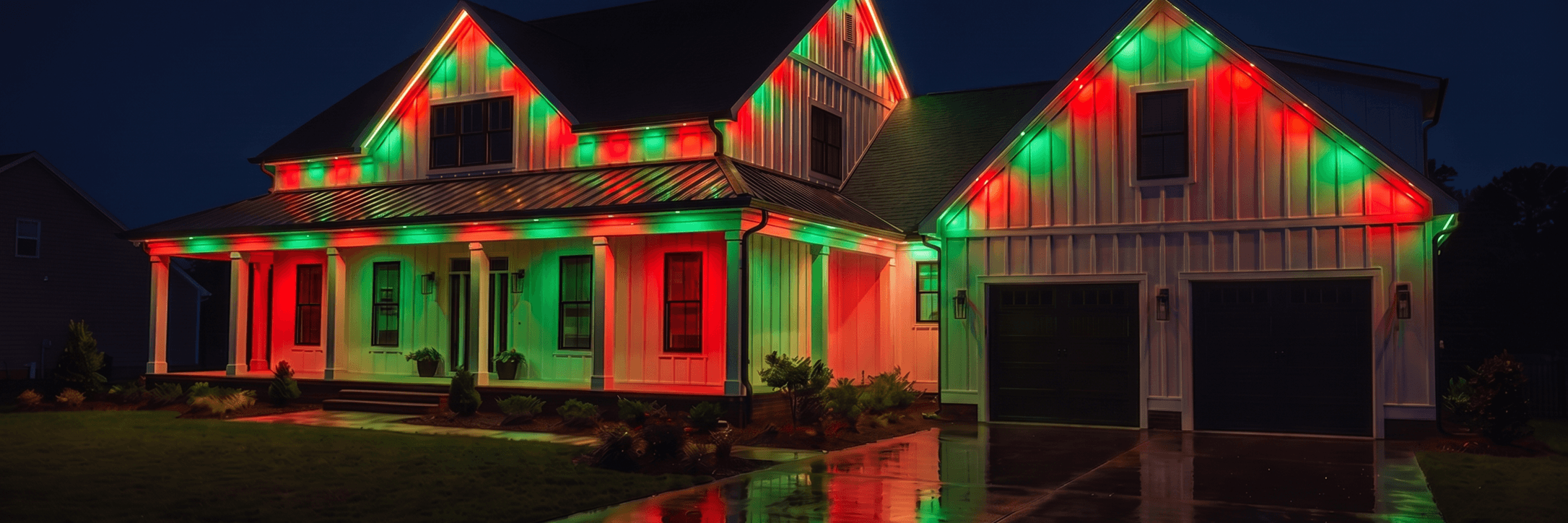 Traditional siding house viewed closely from the driveway at night, with christmas roofline lighting